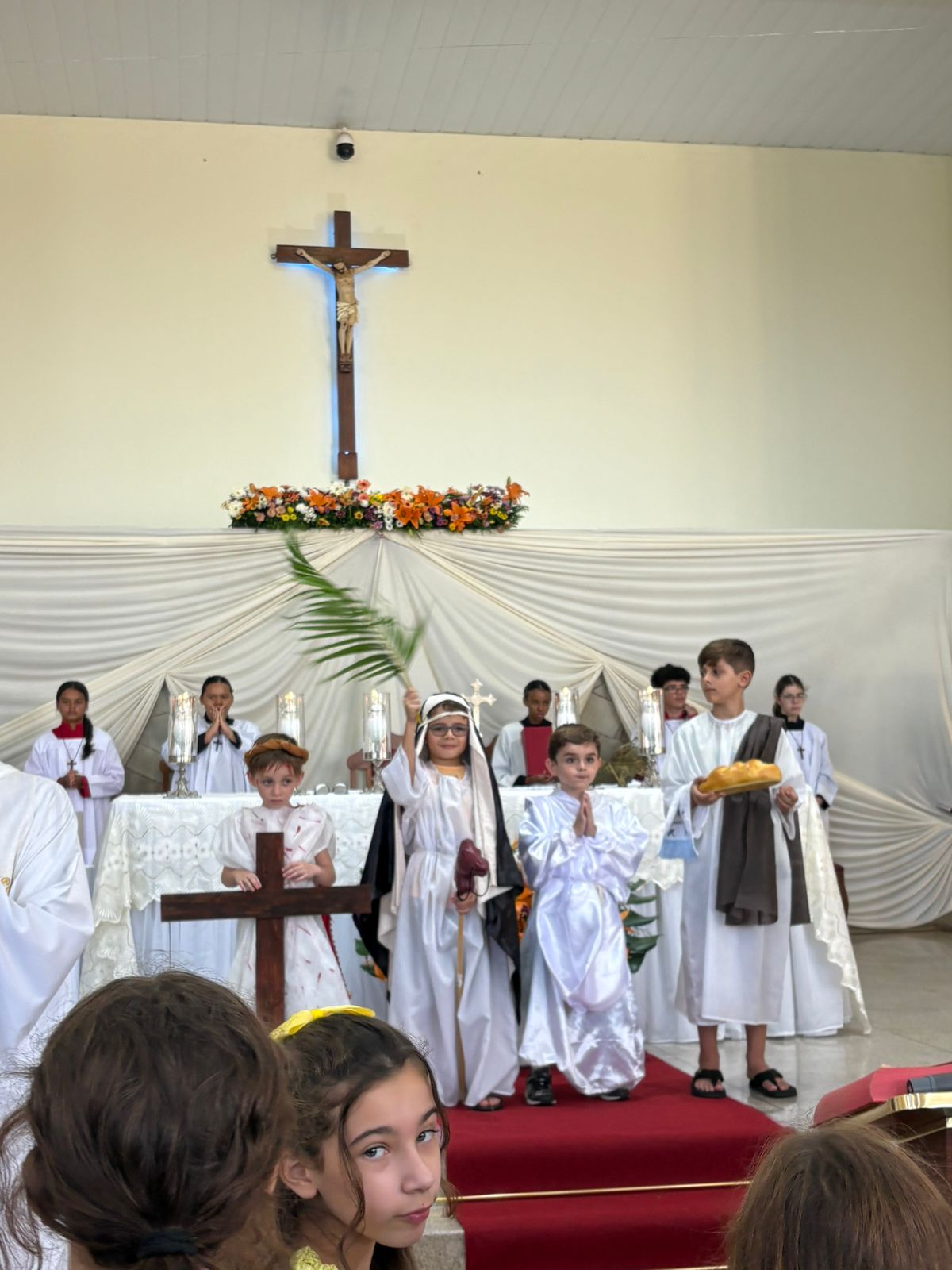 Crianças da catequese caracterizadas diante do altar