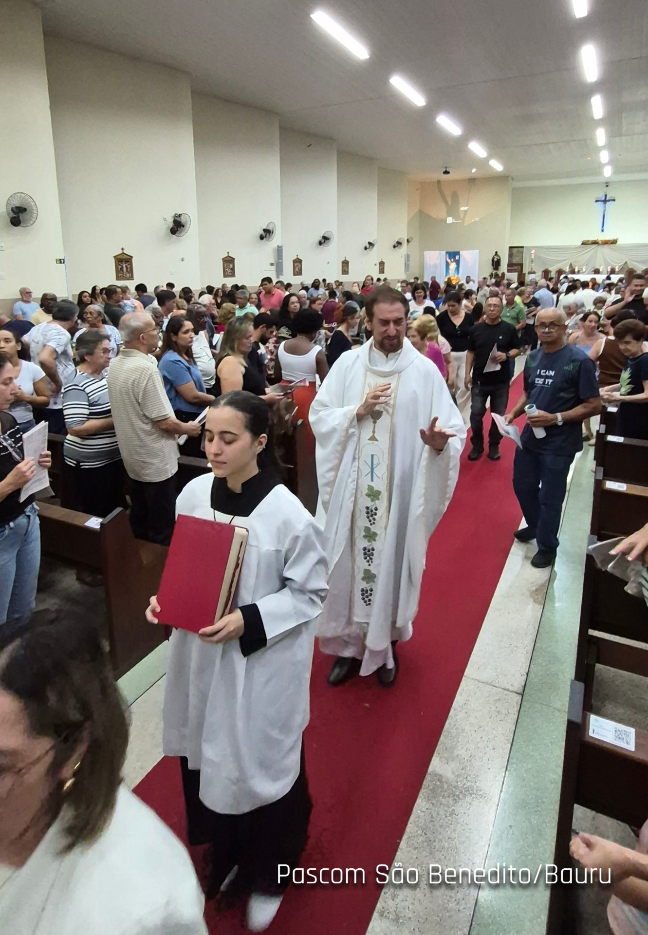 Padre em procissão de saída abençoando os fiéis