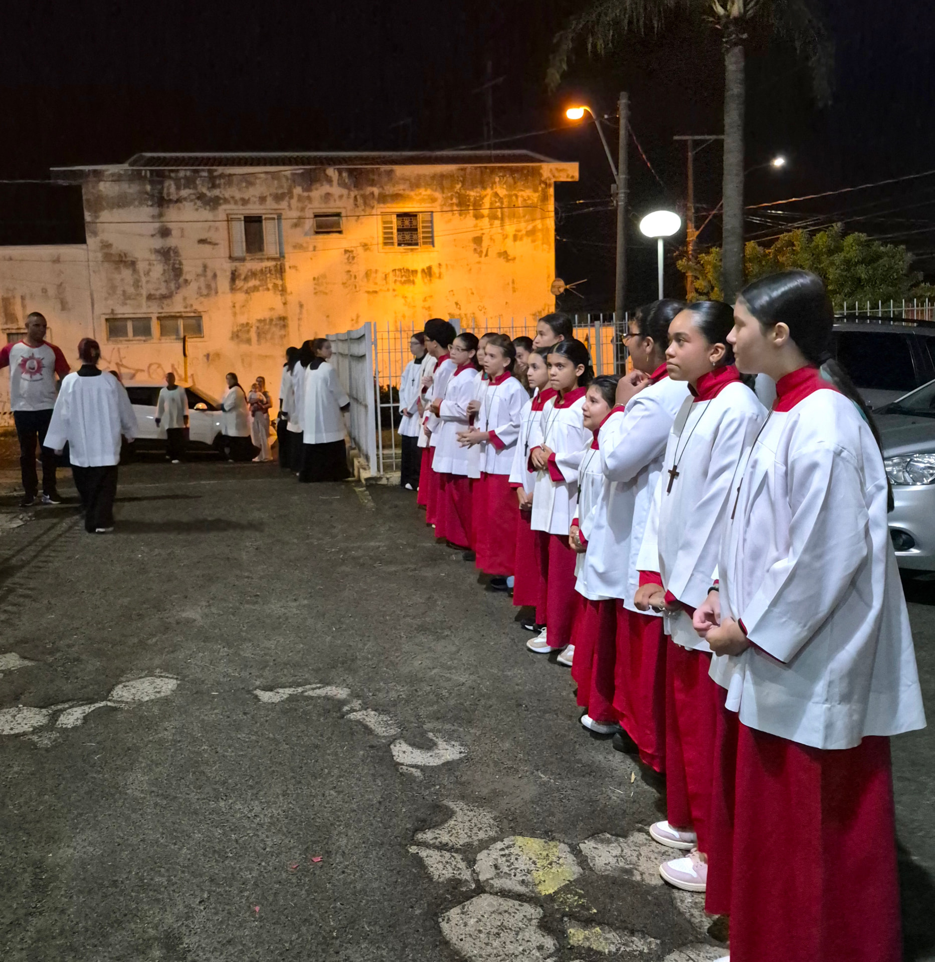Coroinhas perfilados do lado de fora da igreja durante a procissão
