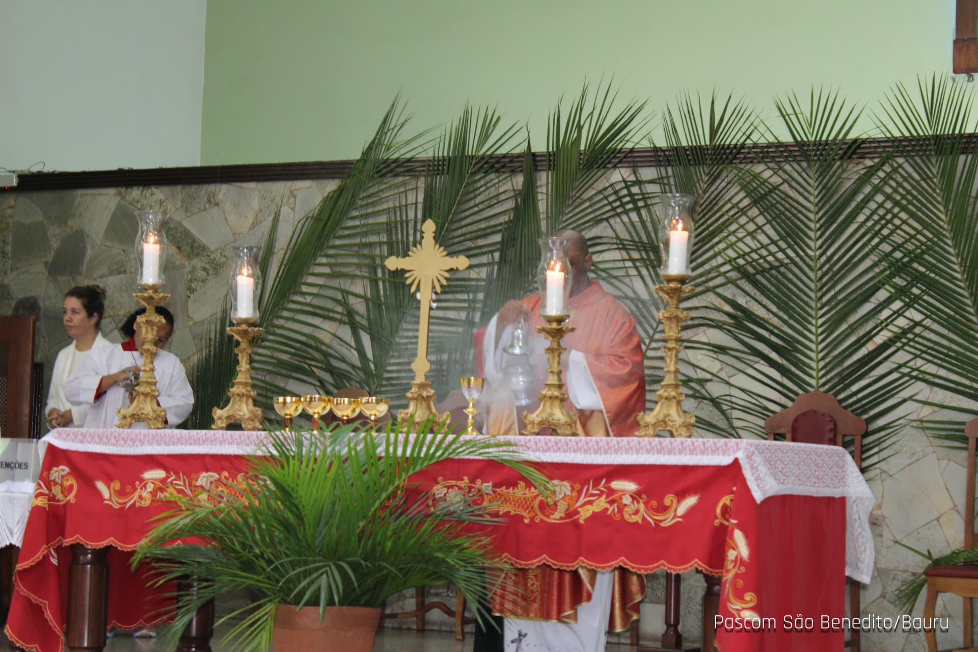 Altar com velas e palmas durante a liturgia